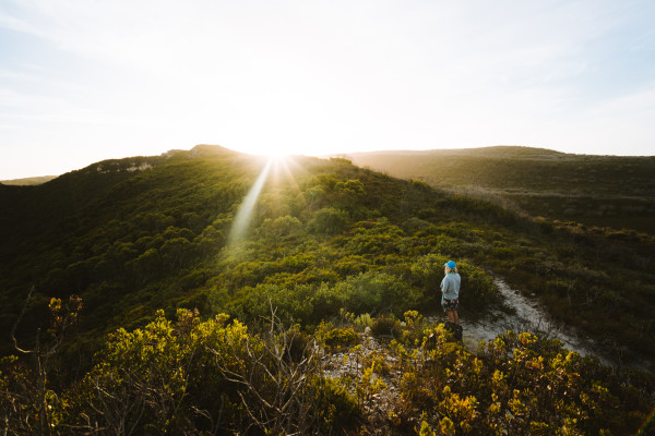 Girl standing alone in the Australian wilderness on the Bibulman hike trail, Albany, Western Australia.